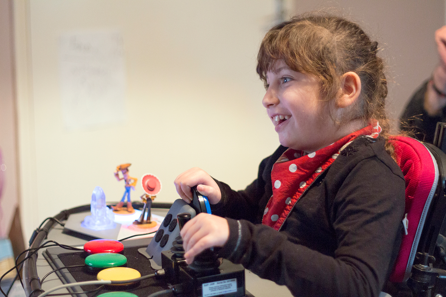 Smiling girl using adapted gaming controls