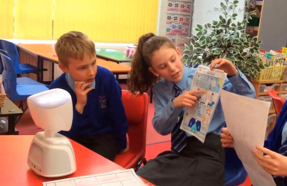 schoolchildren showing a robot a printed page