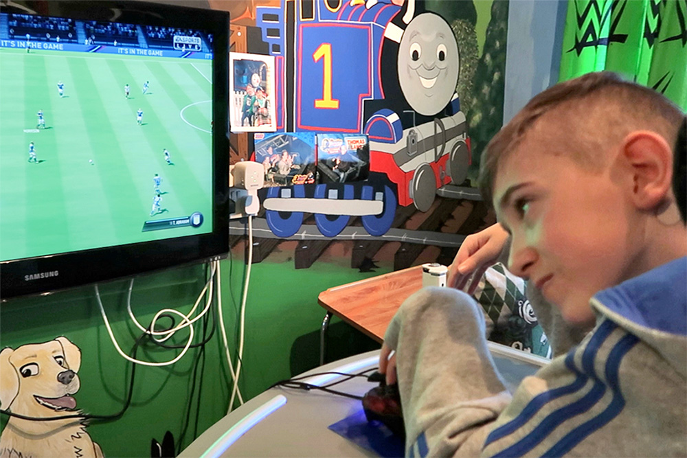 Boy looking at screen containing football video game
