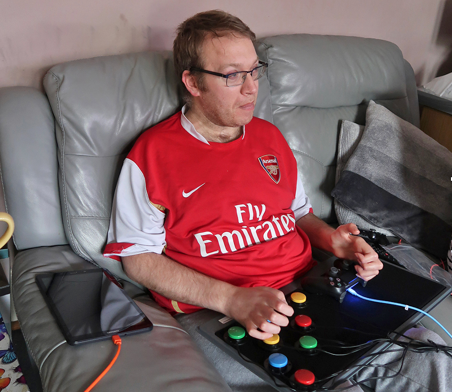 Man sitting on sofa with laptray of button switches