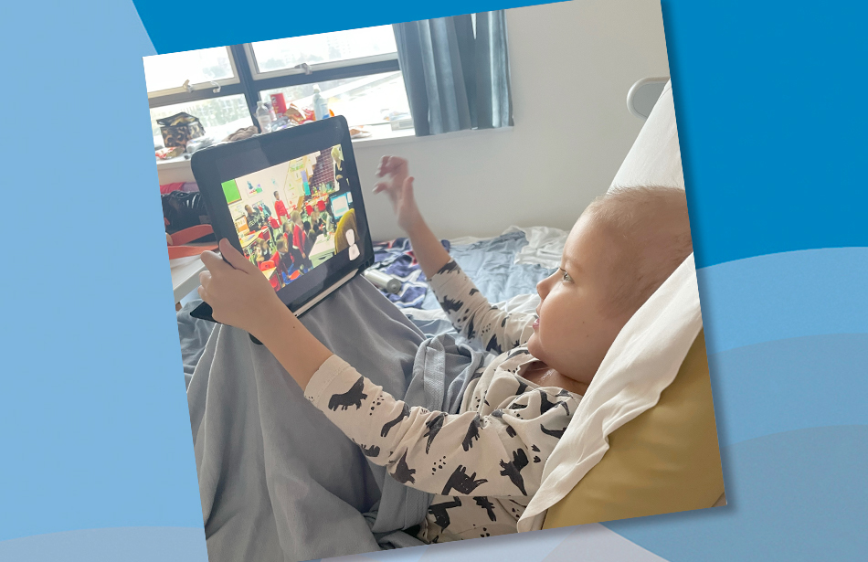 Young boy in bed watching a school classroom live feed on a tablet computer