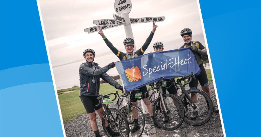 Four cyclists, one with raised arms, underneath a signpost at John O'Groats