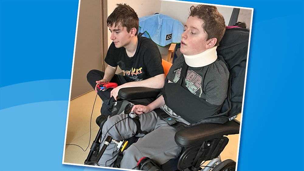 Young man in wheelchair and his brother play games together