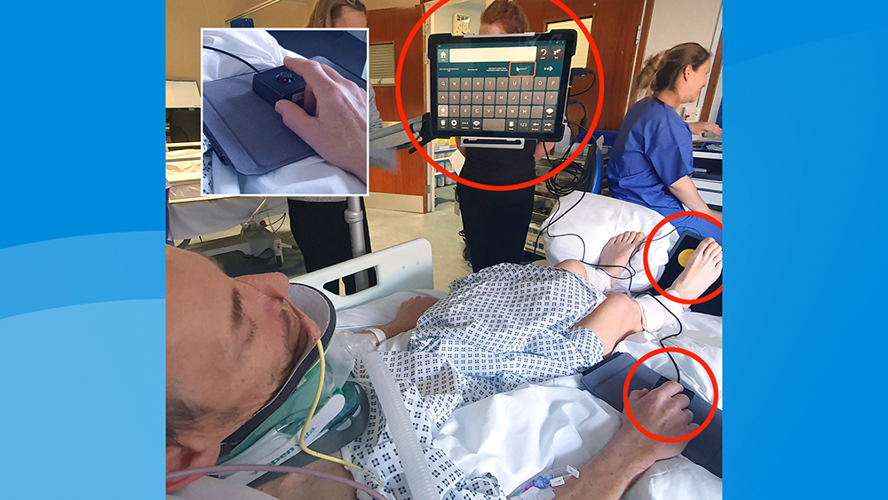 Man in hospital bed looking at a communication grid on a computer screen