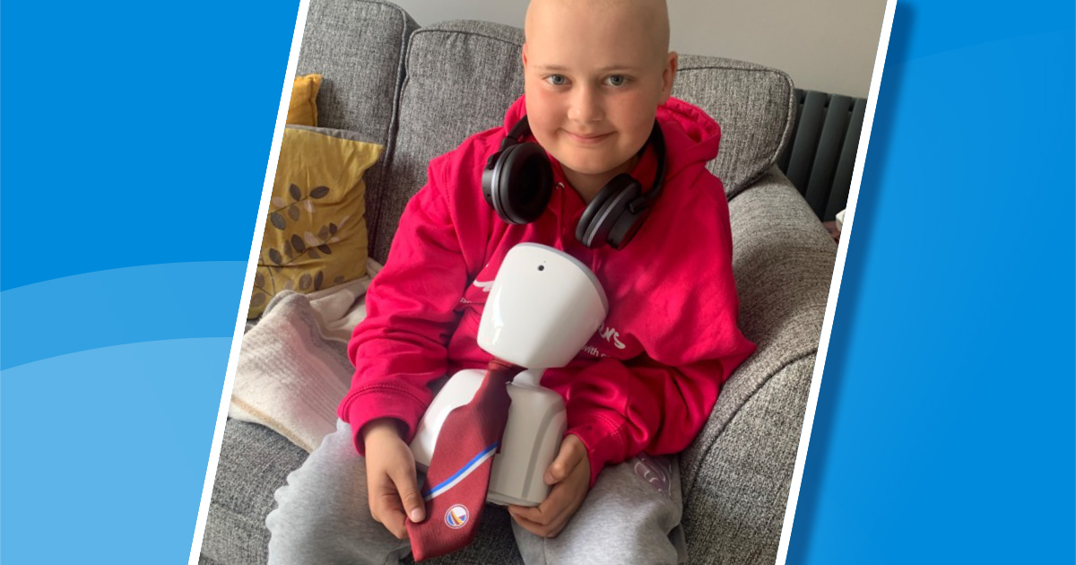 Smiling young boy cradling a small robot that's wearing a school tie