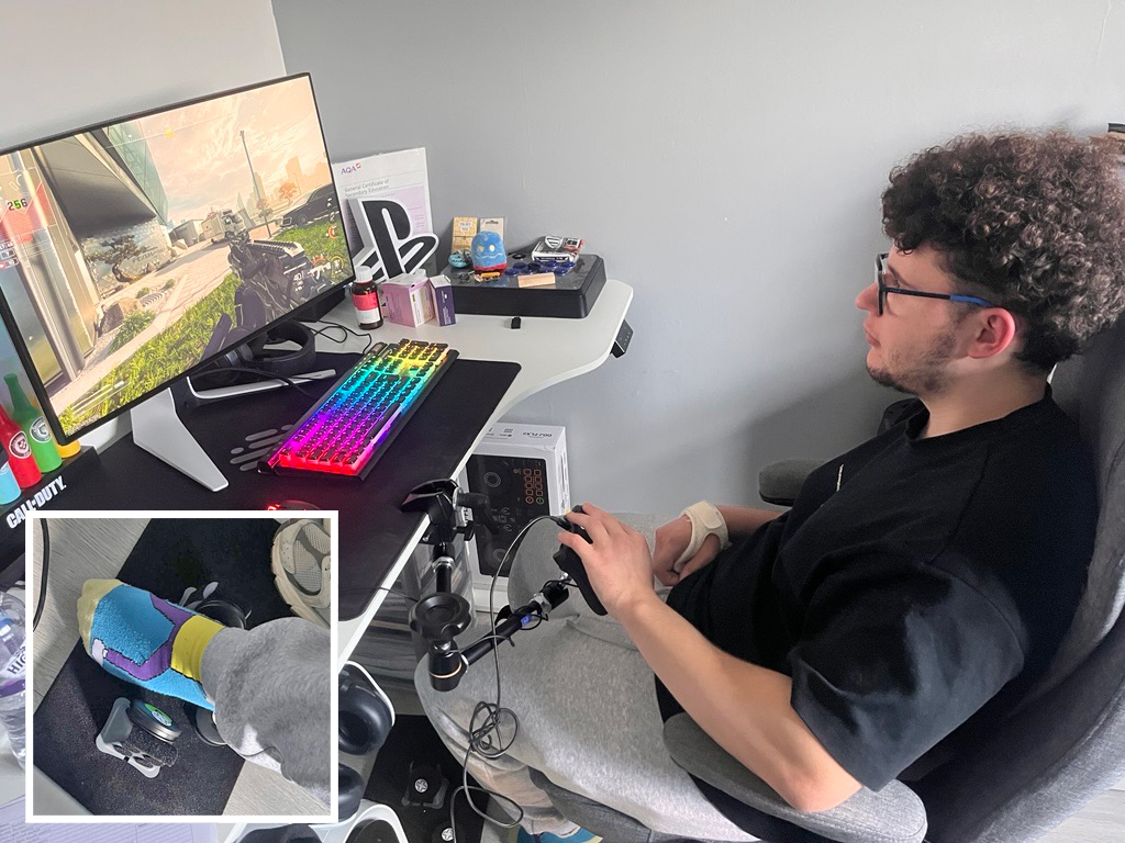 Young man using an adapted gaming controller. Inset shows a close up of his feet.